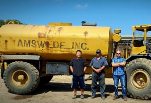 Volvo representative, Amswede representative stand in front of Volvo DR860 articulated hauler. Photo courtesy of Volvo Construction Equipment.