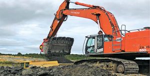 The excavator attachment crushes mined clay down to 4-in.-minus while simultaneously loading haul trucks. Photo courtesy of Allu